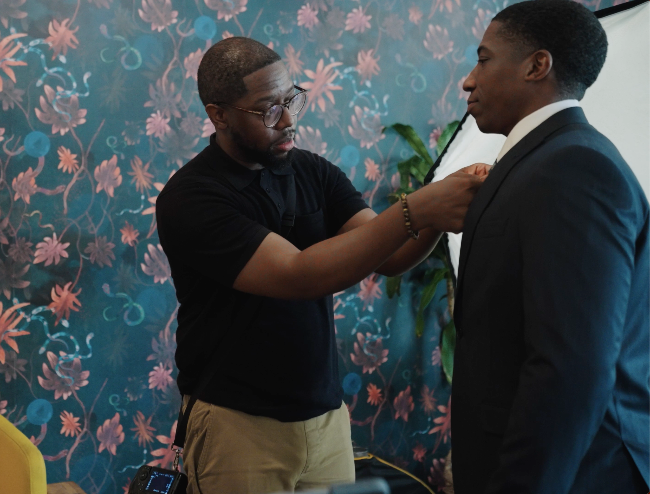 Photographer Jason Bryant helping a client adjust his tie before a professional corporate headshot session in San Antonio, Texas.
