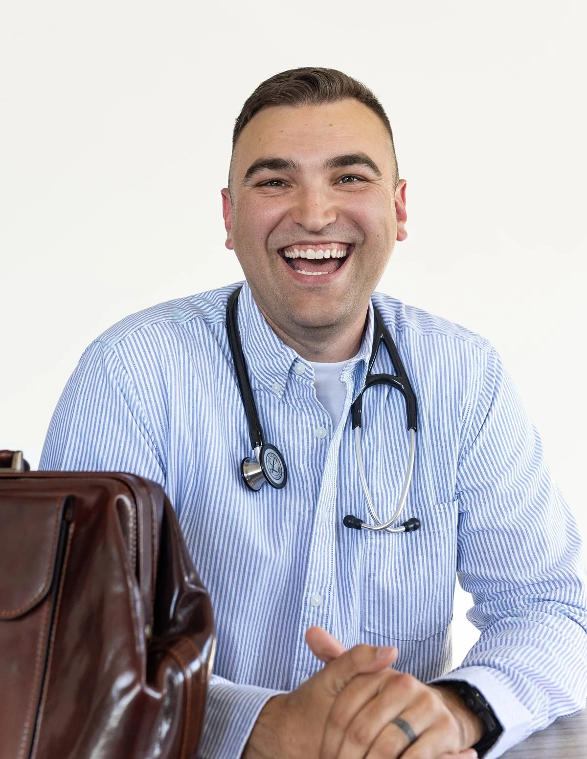 Men’s headshot of a doctor in San Antonio with stethoscope and approachable smile.