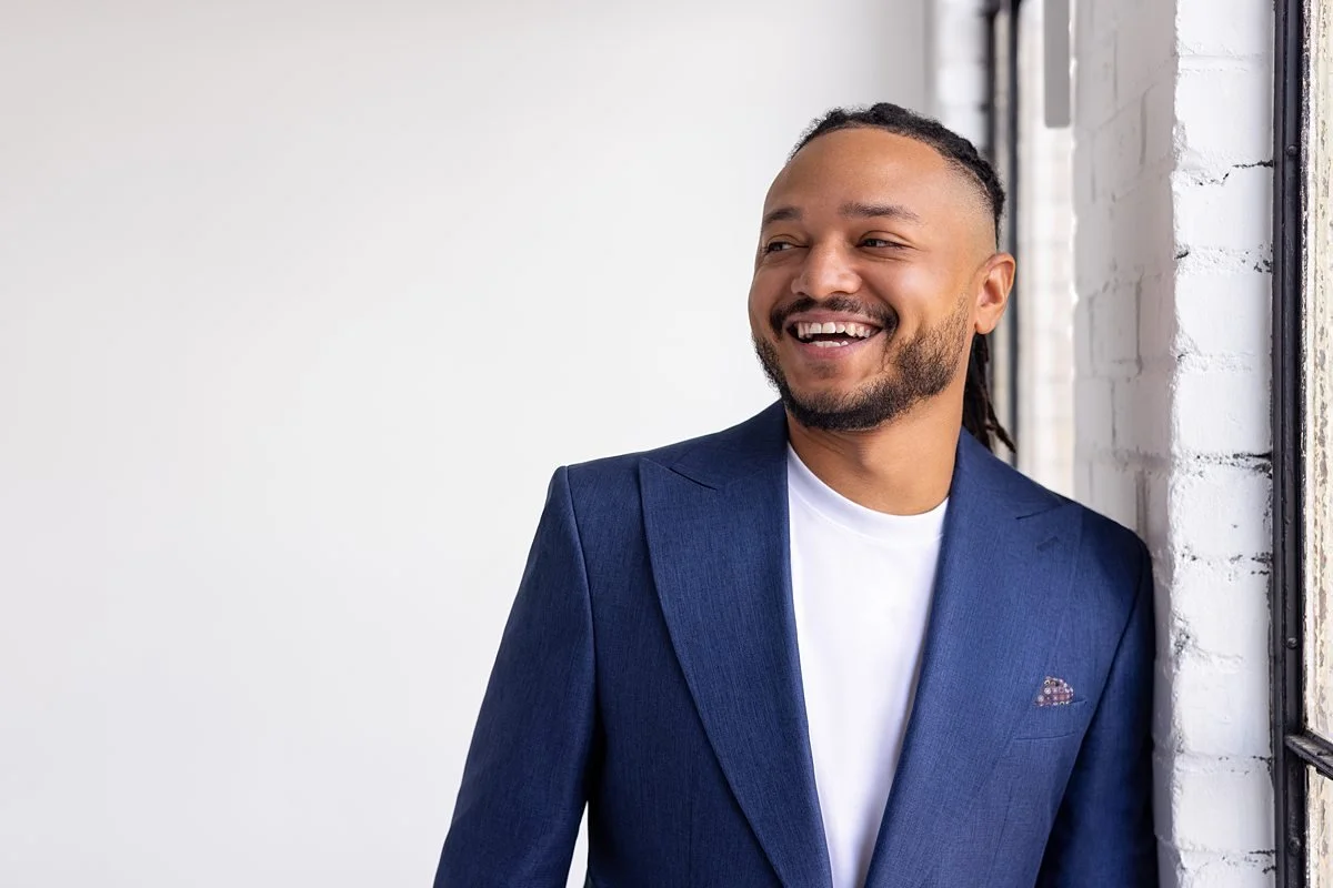 Modern men’s headshot in San Antonio with navy blazer and relaxed, confident smile.