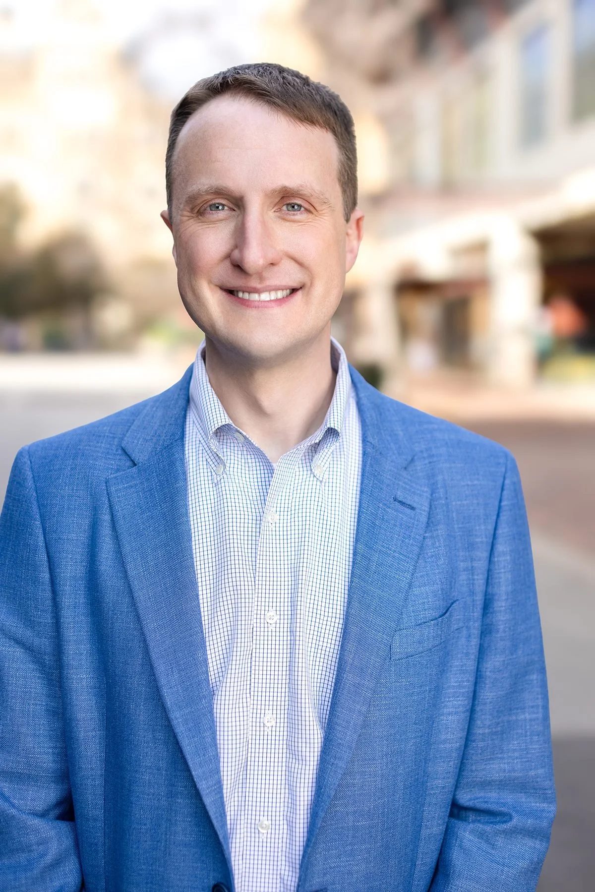 Professional men’s headshot in San Antonio with blue blazer and confident smile.