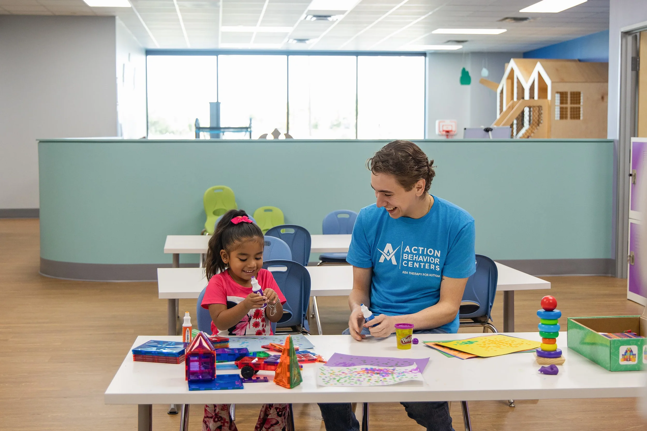 Child and therapist engaged in a creative learning activity at Action Behavior Centers in San Antonio, Texas, during an ABA therapy session focused on play-based development.