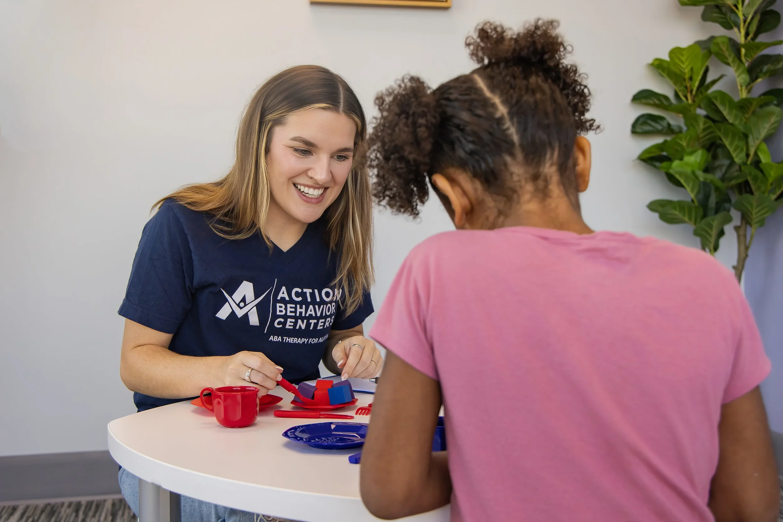 Therapist conducting one-on-one ABA therapy with a child at Action Behavior Centers in San Antonio, focusing on communication and cognitive development.