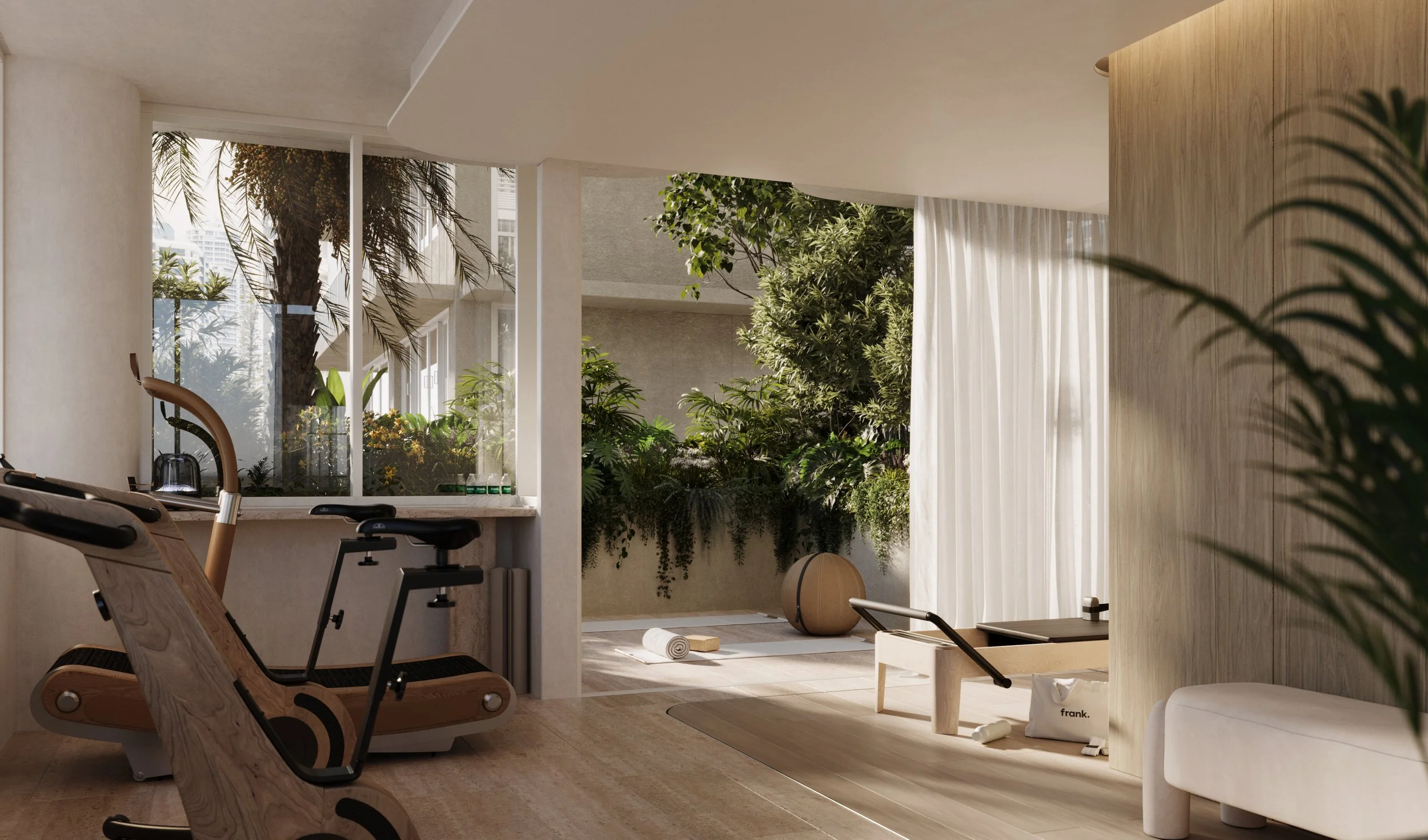 Indoor fitness room with exercise equipment, a large window showing outdoor greenery, and natural light.