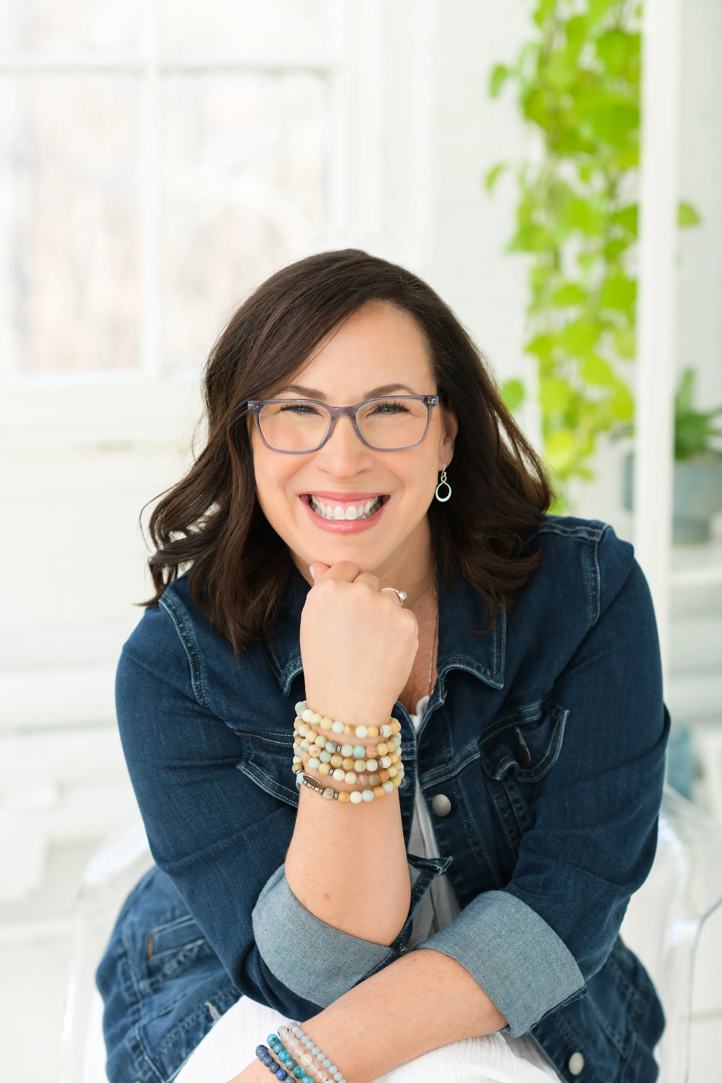 Jill Vetstein is in her Natick, MA office wearing a denim jacket, glasses and an amazonite bracelet.