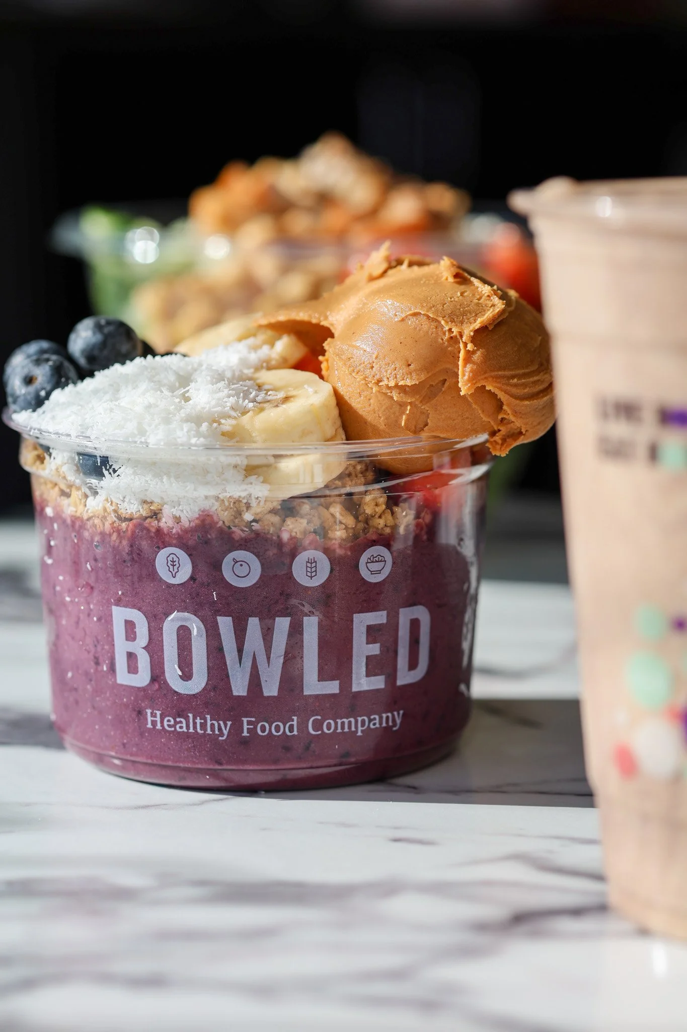 Açaí smoothie bowl topped with banana, berries, granola and a drizzle of honey, food photography for a café in the Capital Region of New York