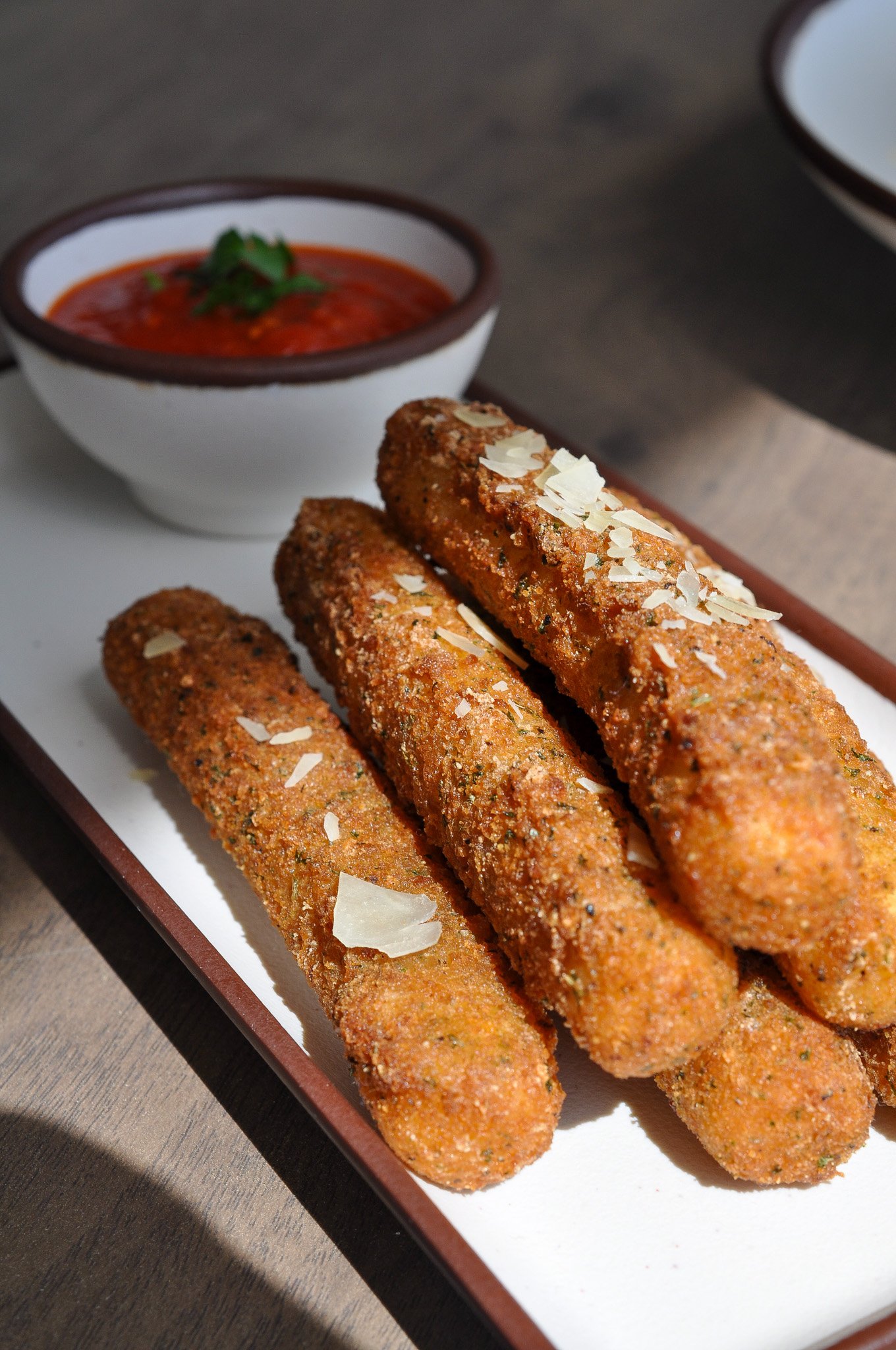 Crispy golden mozzarella sticks with a side of marinara dipping sauce, food photography for a Latham, NY deli
