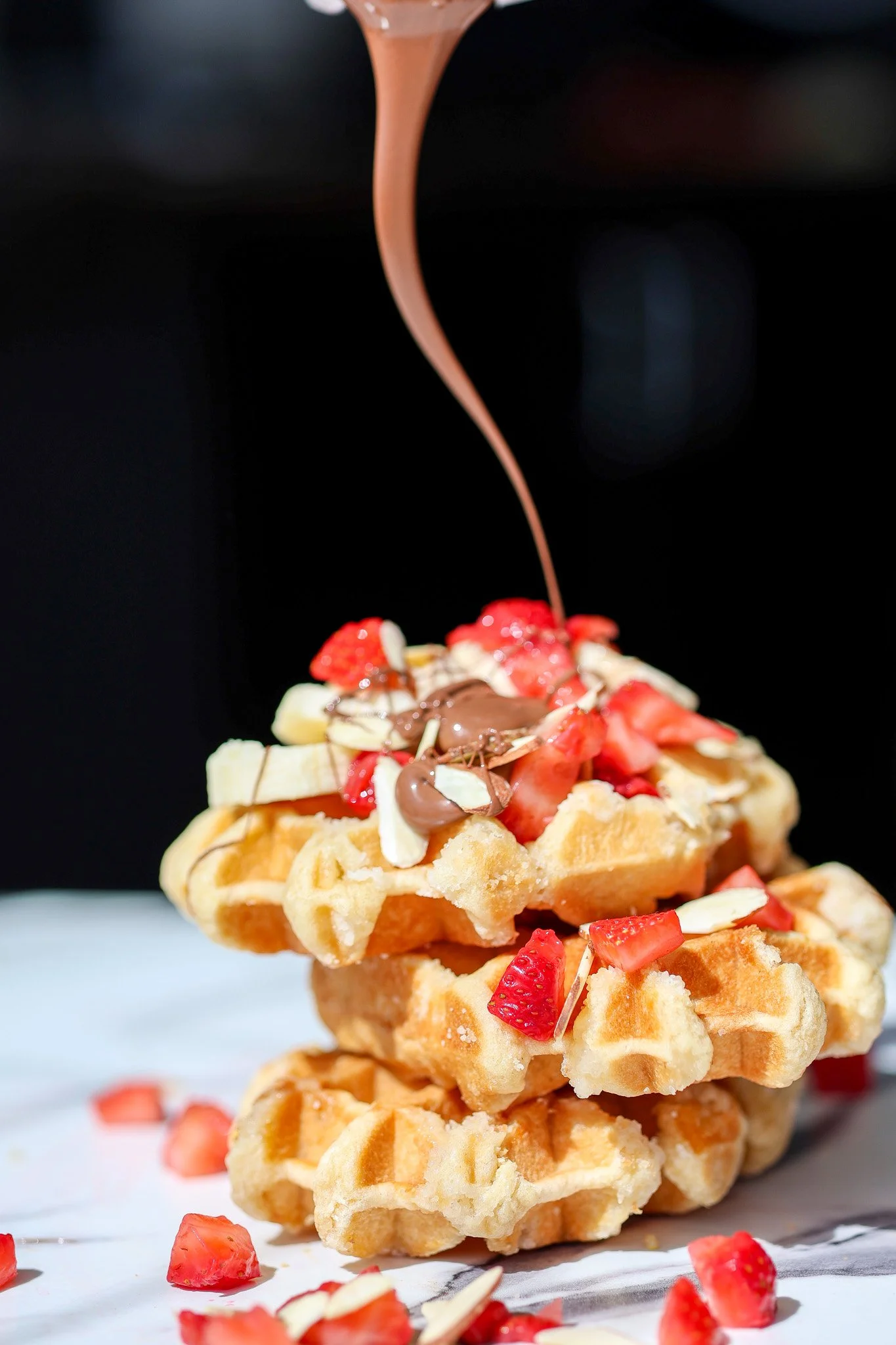 Golden Belgian waffle topped with fresh berries, nutella and nuts, food photography for an Albany, NY restaurant