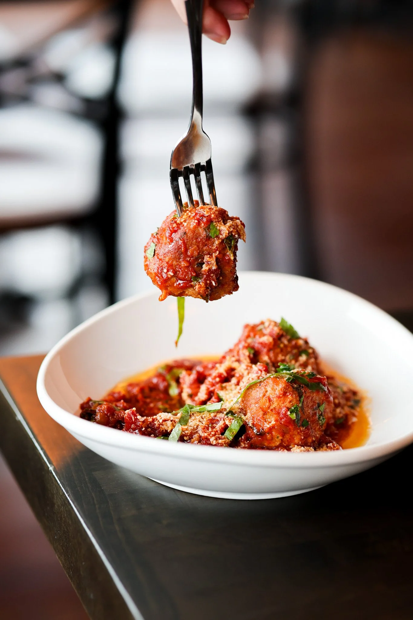 Homemade Italian meatballs in marinara sauce topped with fresh basil and parmesan, food photography for a Ballston Spa, NY Italian restaurant