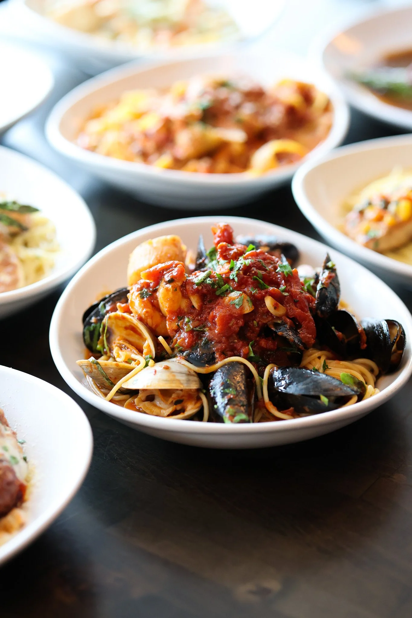 Plate of pasta tossed in a rich tomato sauce with fresh basil and parmesan, food photography for a Lakewood Ranch, FL restaurant