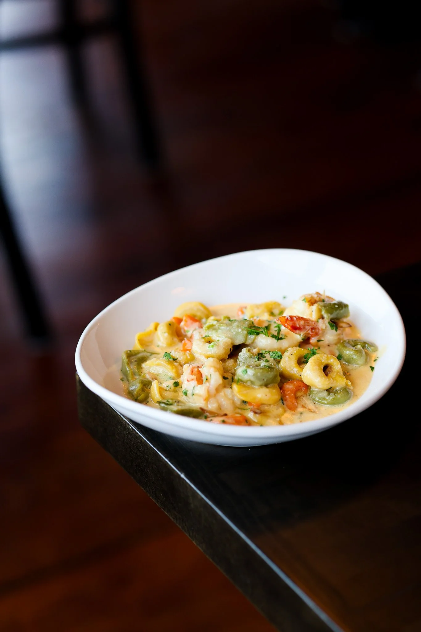 Plate of cheese tortellini in a creamy sauce topped with fresh basil and parmesan, food photography for a Saratoga Springs, NY restaurant