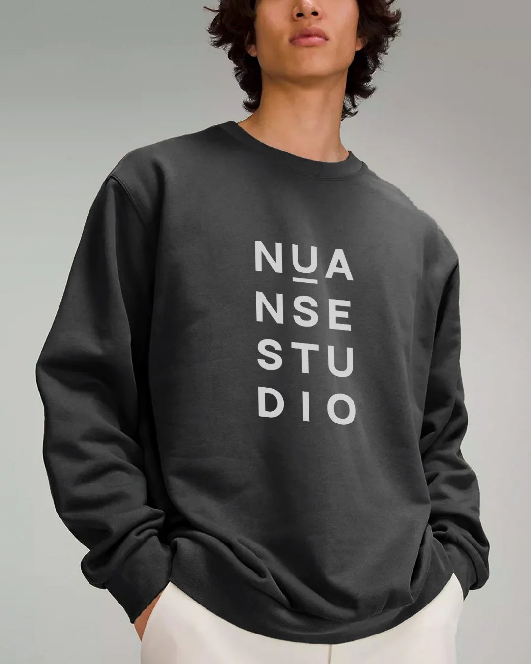 Person wearing a black sweatshirt with "NUANSE STUDIO" printed vertically in white letters.