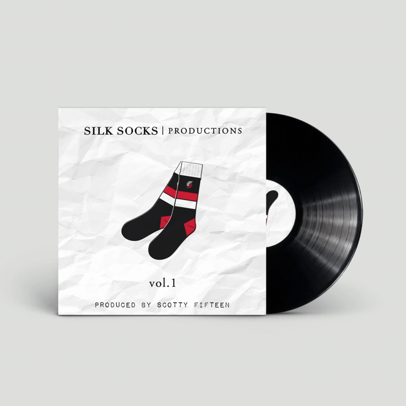 Vinyl record with album cover featuring black and red socks illustration and text "SILK SOCKS PRODUCTIONS vol. 1 Produced by Scotty Fifteen."