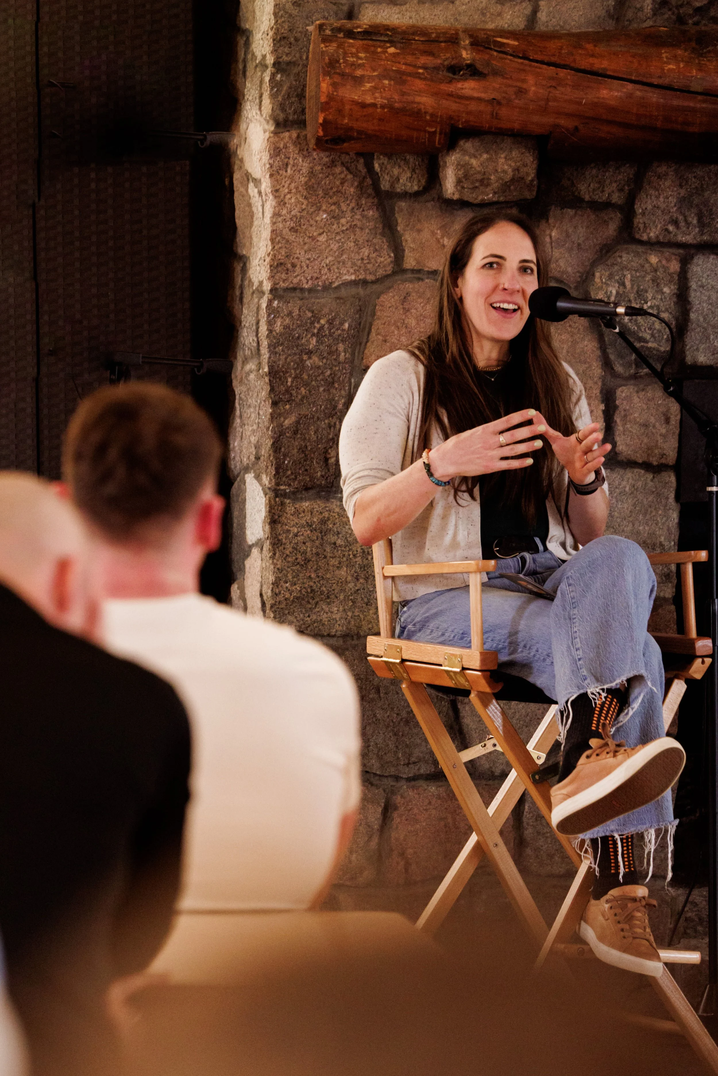 Dr Erin Ayala sitting in a chair speaking into a microphone at an event