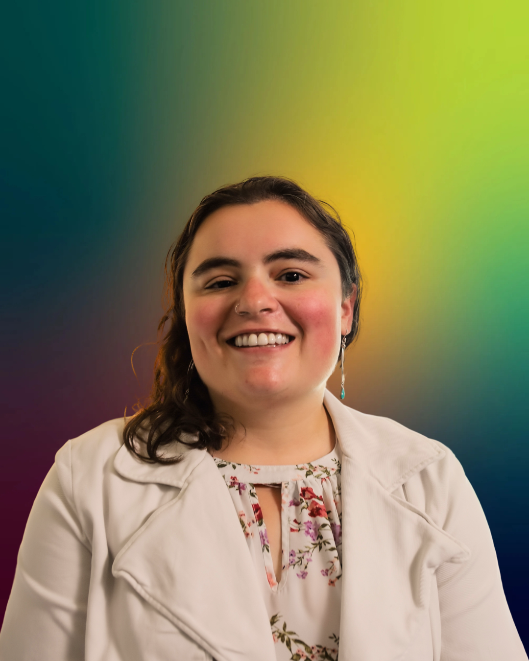 Person smiling in front of a colorful gradient background.