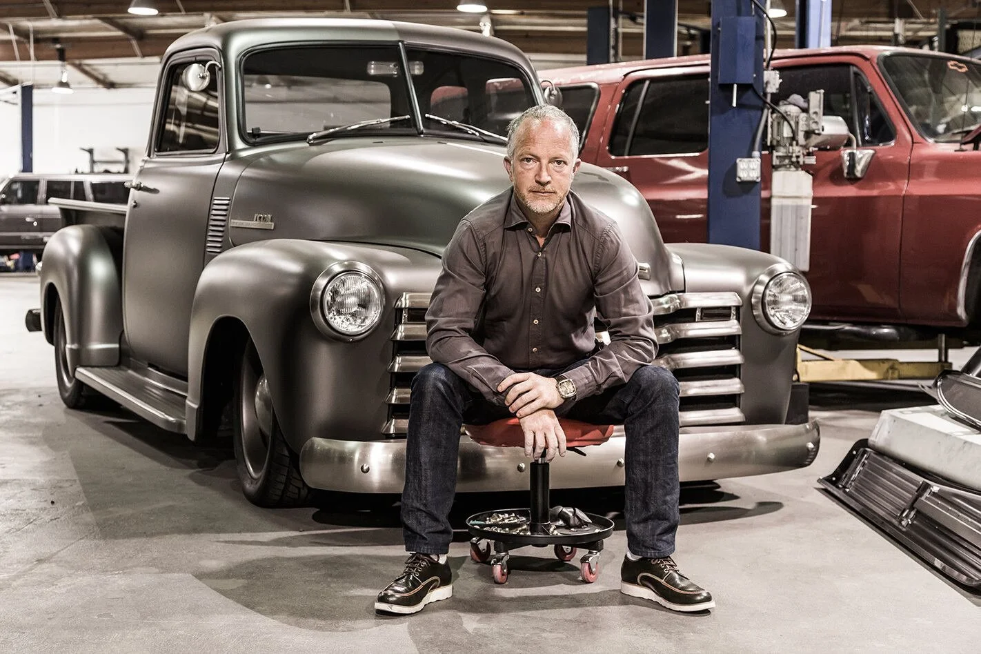 Jonathan Ward, founder of ICON, seated in front of an ICON truck at his workshop