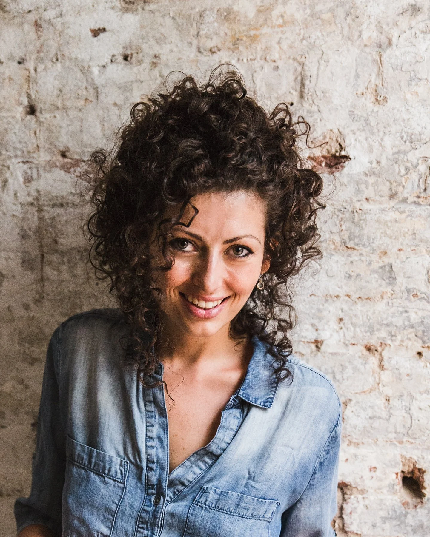 Elisa Marshall, founder of Maman, smiling in front of a brick wall
