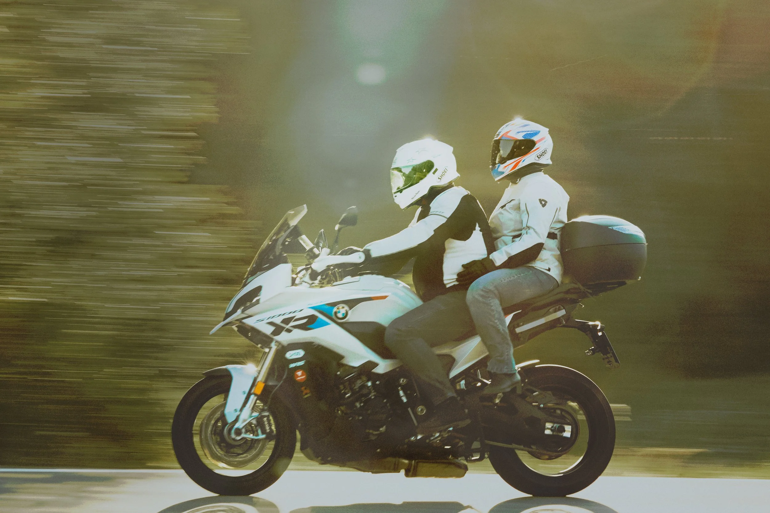 Dvojice na motorce při jízdě zachycená technikou panning