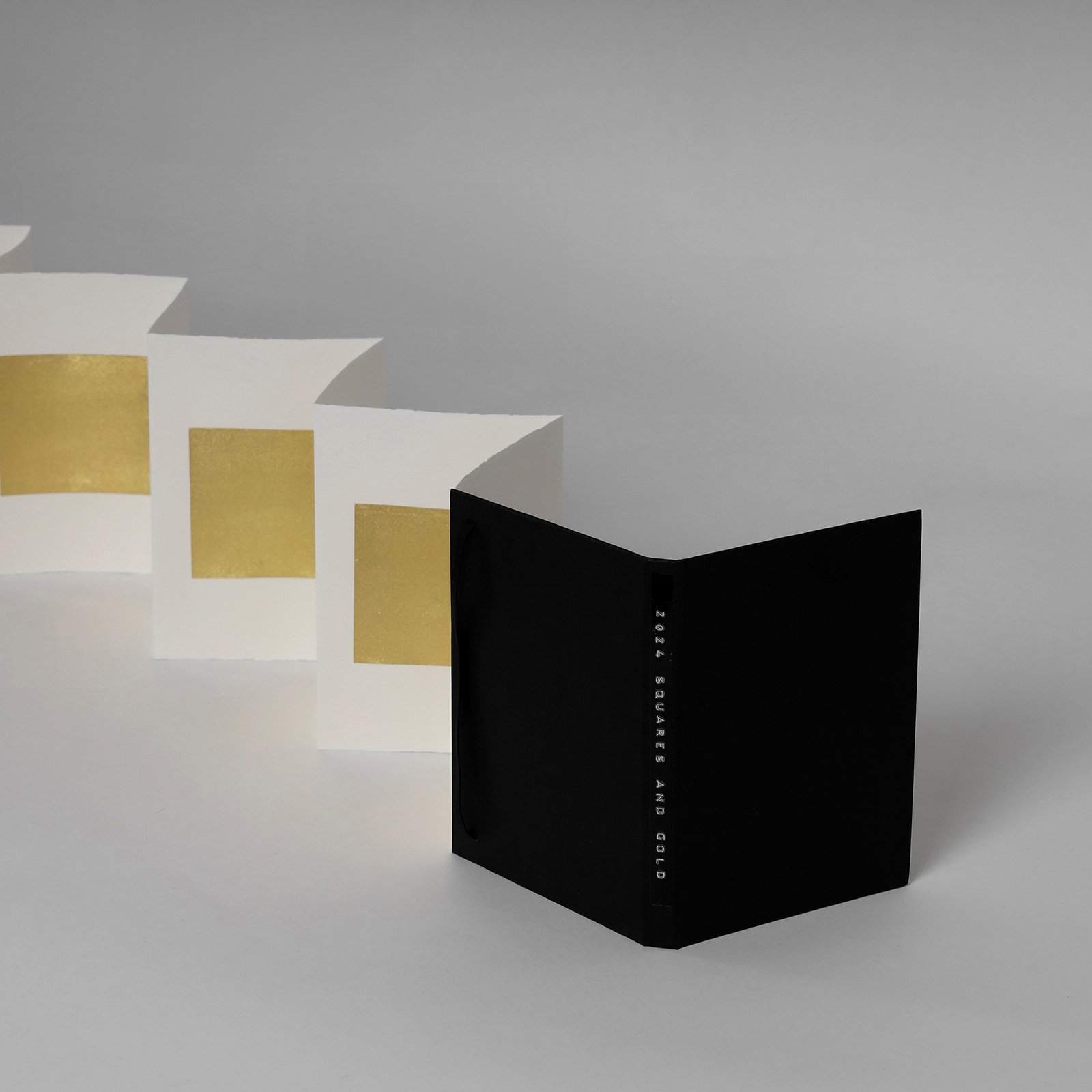 With each delicate sheet, the air seems to be still. Time bends. A special connection unfolds. The gold tries to lie on the surface, but it merges with the stone, a kind of alchemy. 
 
Squares and Gold, Gold on paper, 2024, Leporello / 18 x 12 x 240 