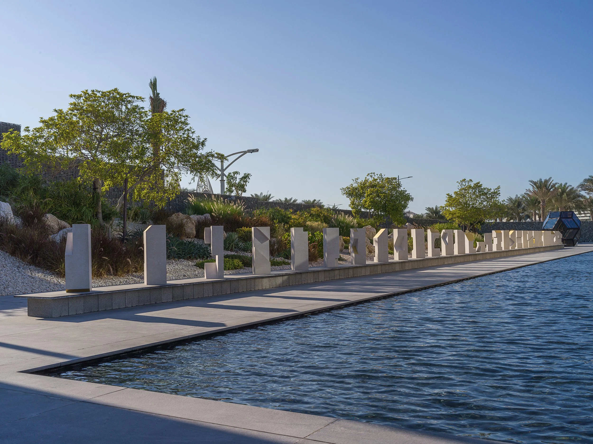 Tarek Elkassouf طارق القاصوف — Boundaries, a large-scale public art installation at Bassam Freiha Art Foundation, Abu Dhabi. This monumental UAE sculpture series features 29 hand-carved limestone and 22k gold leaf
