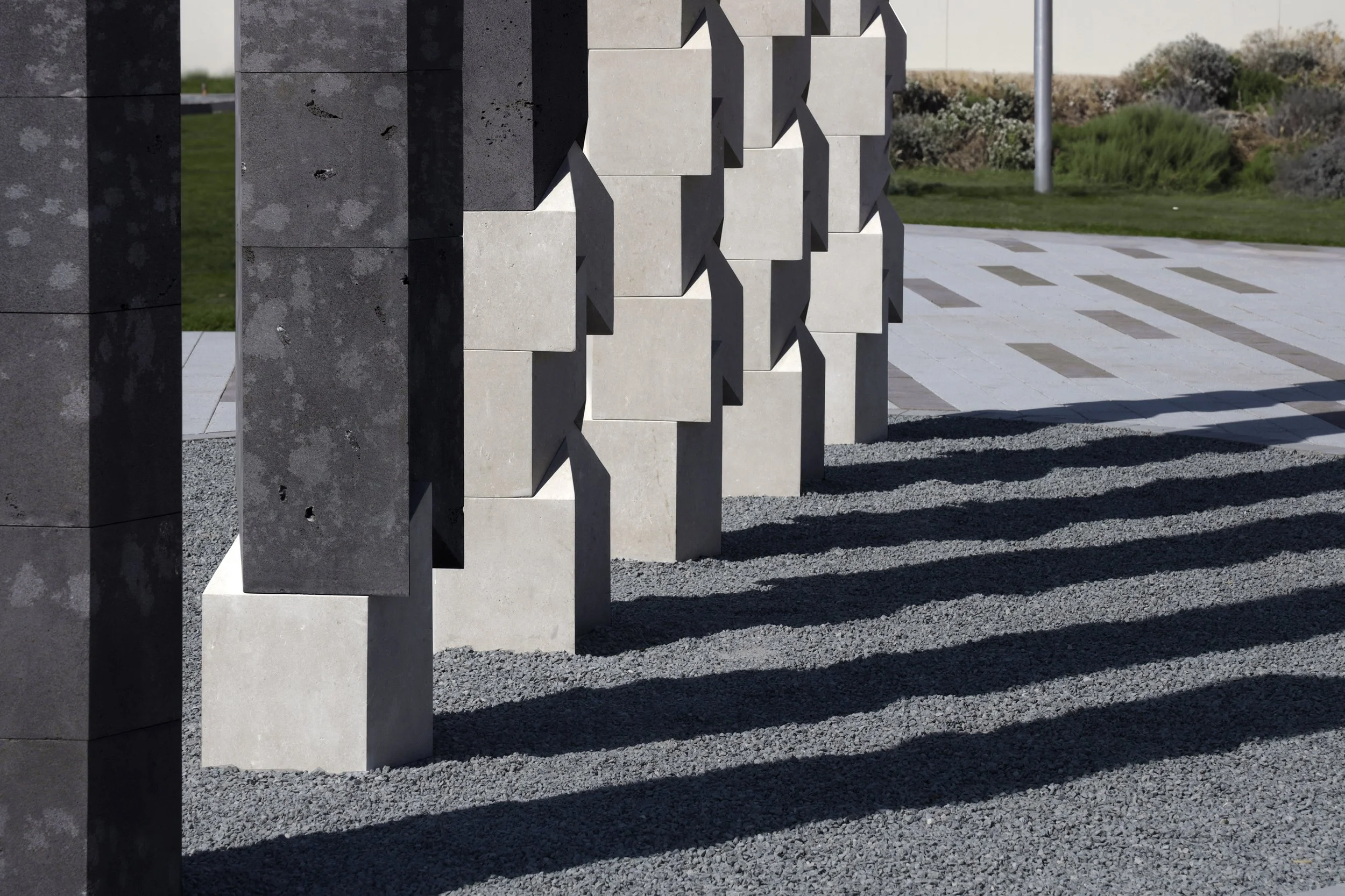 Tarek Elkassouf طارق القاصوف — Transformative Energy, record-breaking large-scale public artwork Jubail Island, Abu Dhabi. Monumental UAE installation, six pillars, limestone and basalt, first permanent sculpture of Jubail Public Art Programme.