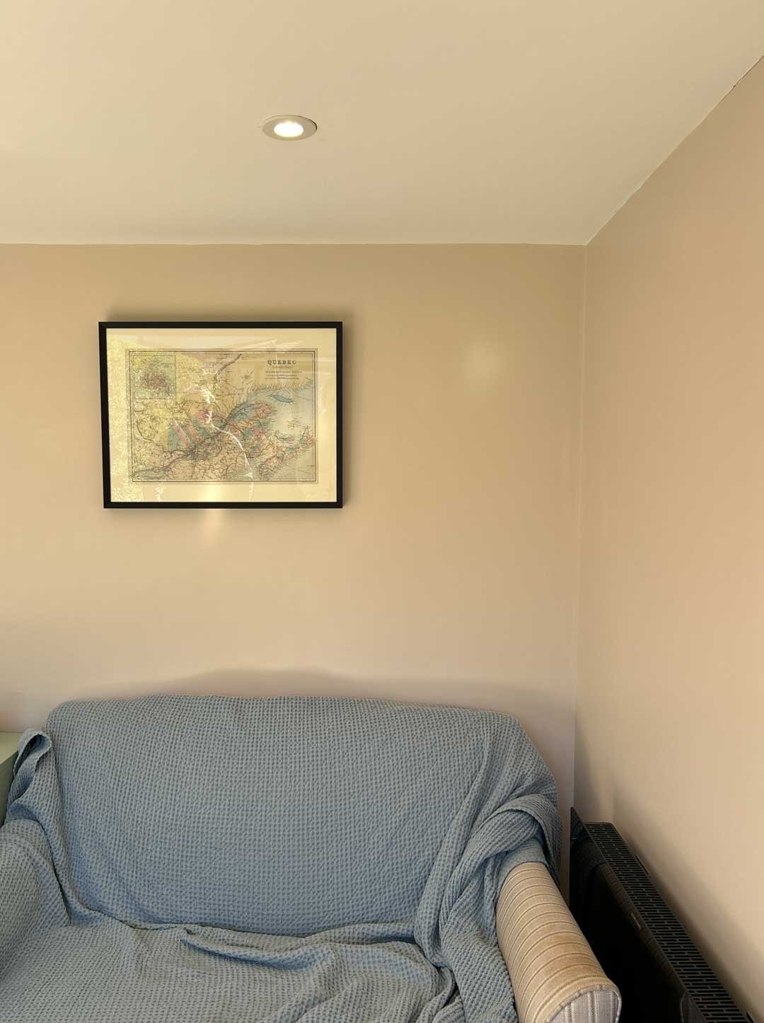Interior corner of garden room with soft furnishings and framed wall art