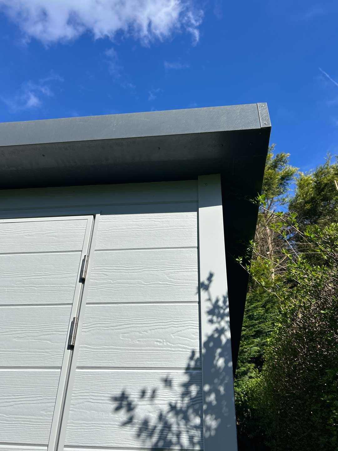 Roofline detail of bespoke garden room with overhang and composite cladding finish
