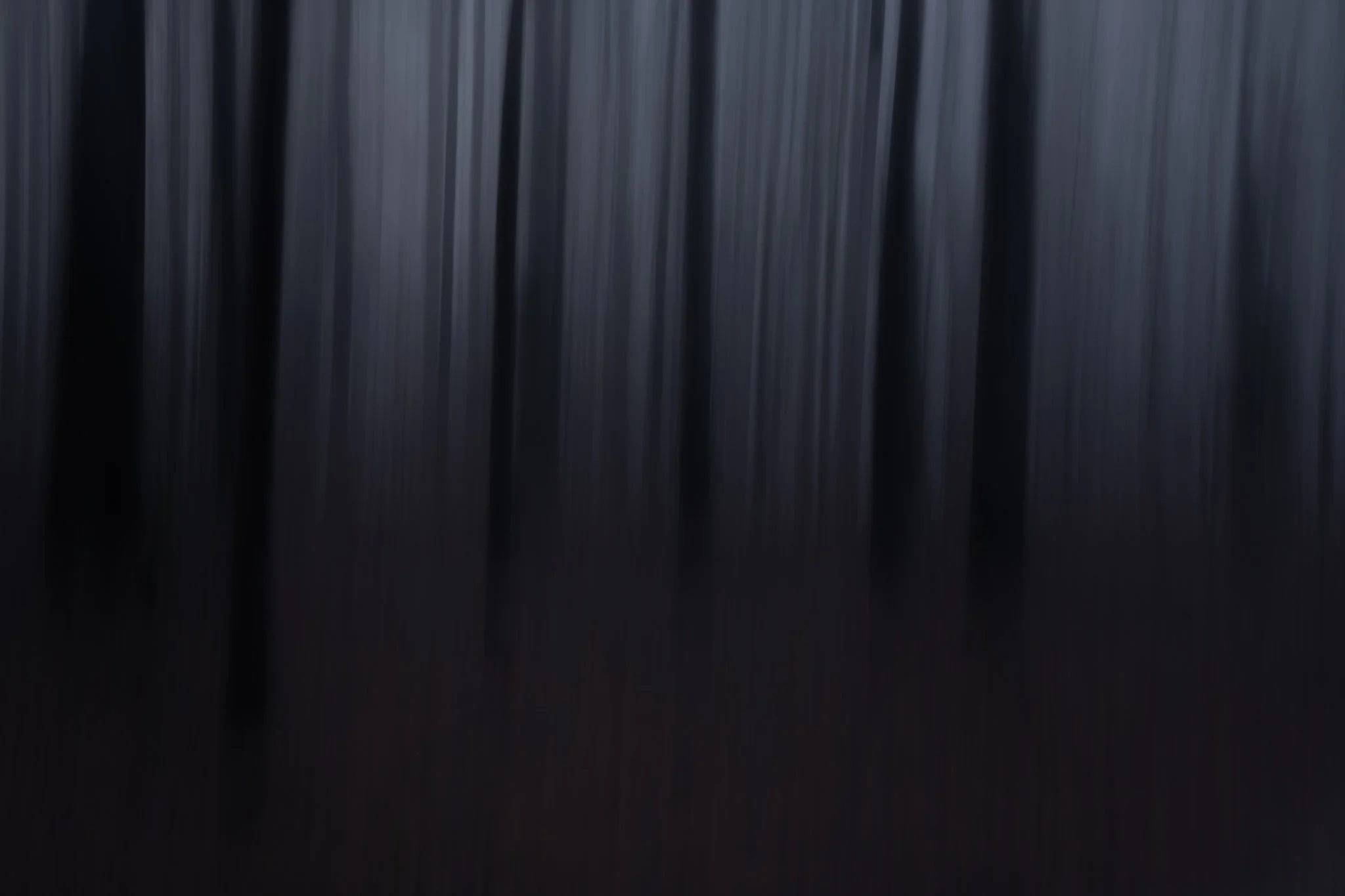Close-up of a black curtain with vertical folds.
