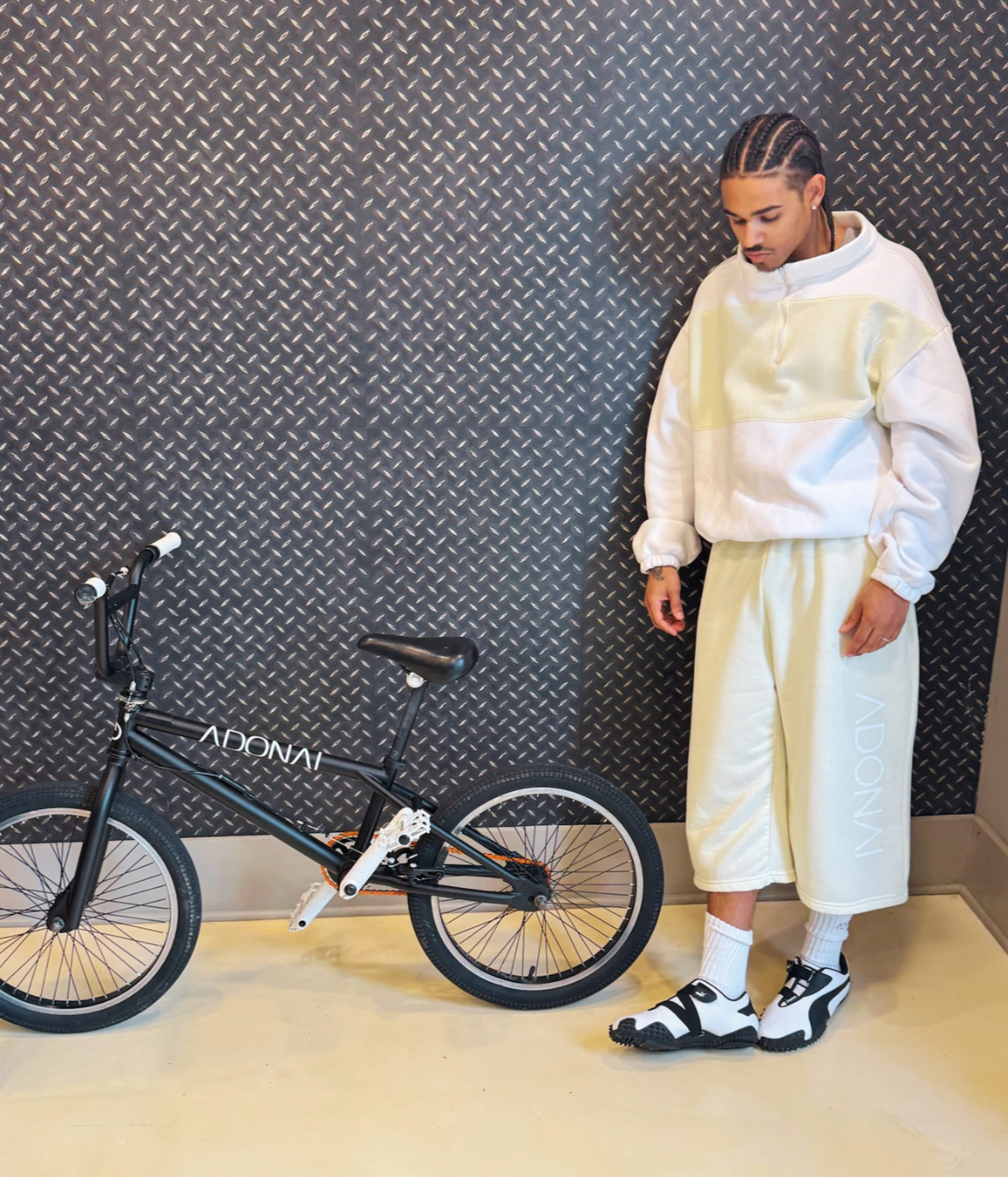 Model wearing Luxury Capri or 3/4 or Long shorts. Yellow oversized shorts, heavyweight cotton, fleece, sweat shorts, fashionable trending. oversized logo, street style. bike street style, fashion luxury fashion, styled.
