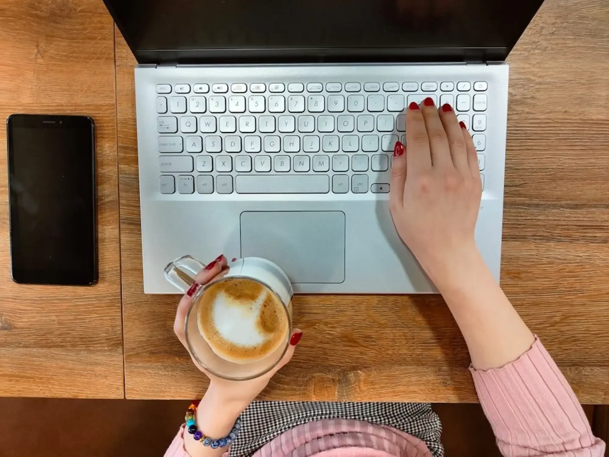 woman with coffee working on laptop