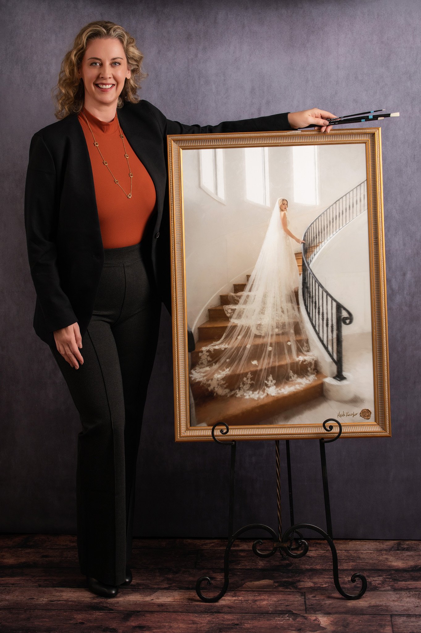 Heidi Knight, mixed media artist, poses with a bridal portrait and brushes