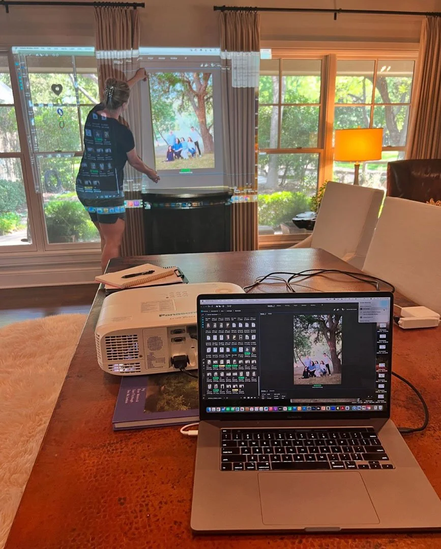 Heidi Knight projecting family portrait artwork onto a wall to determine ideal size and placement before creating a commissioned portrait.
