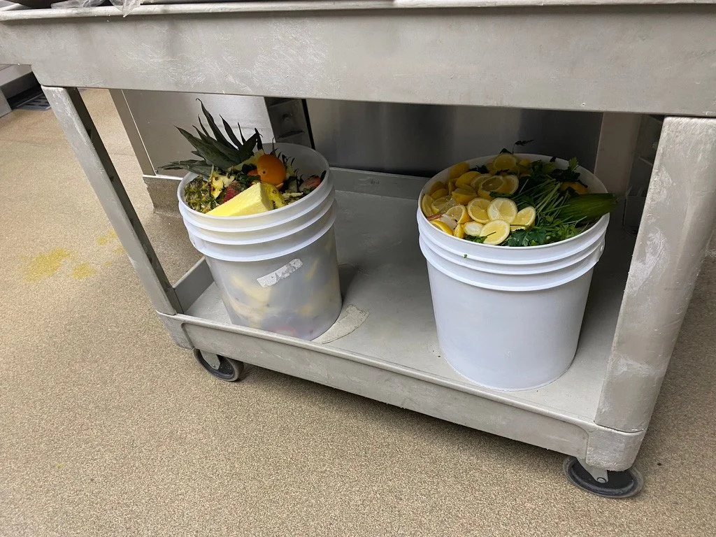 Kitchen food scrap collection buckets on a cart, part of a working waste diversion system