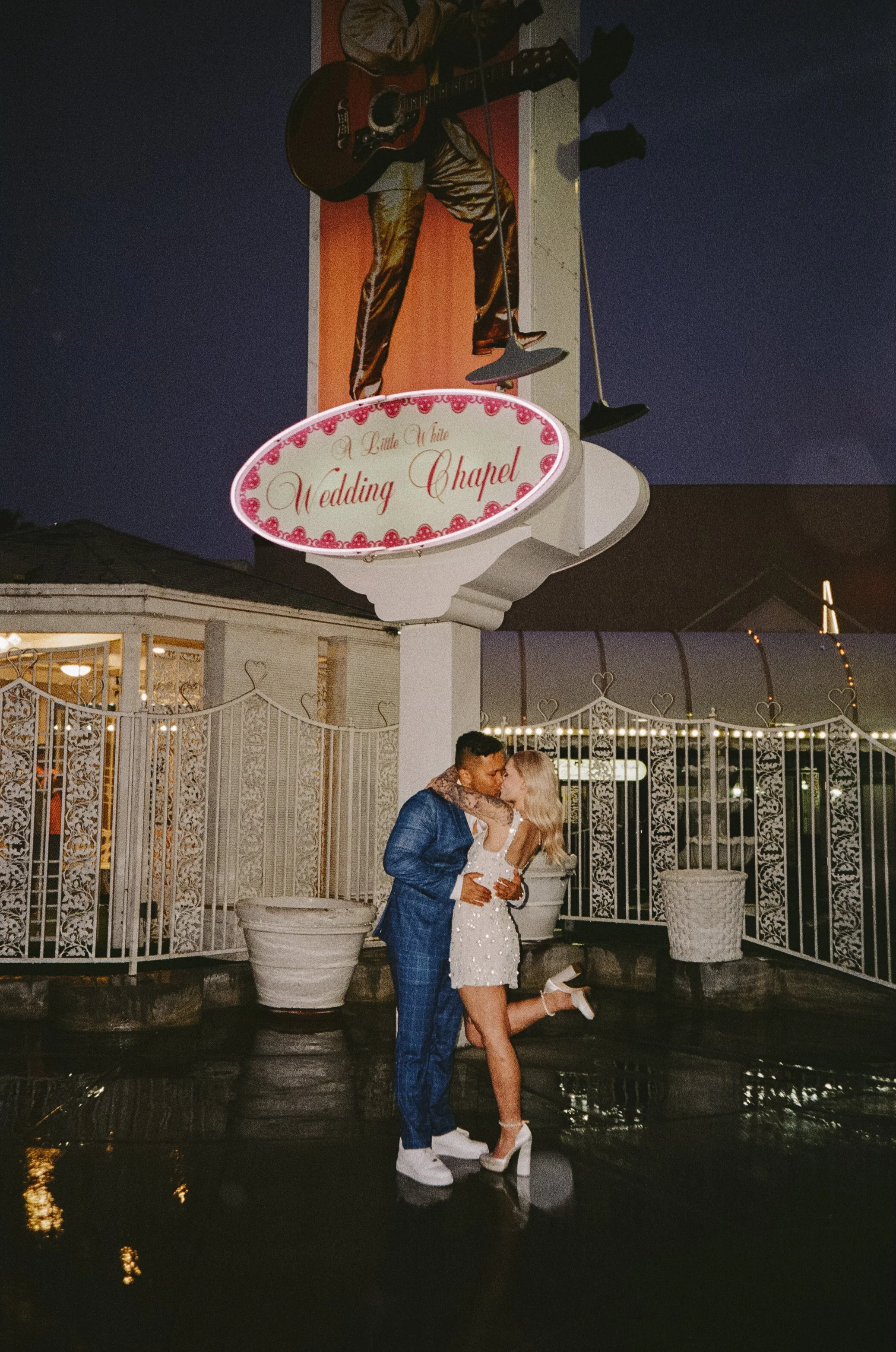 Couple kissing at a wedding chapel at night