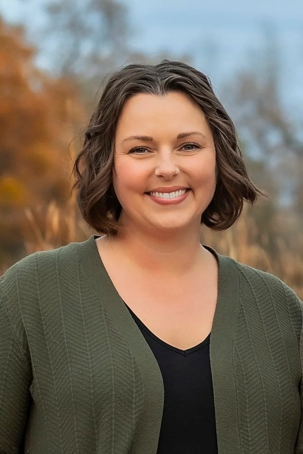 Smiling White woman with short wavy brown hair and a green cardigan. Minneapolis Minnesota Wedding Officiant Officiating Premarital Counseling Premarriage Counselor