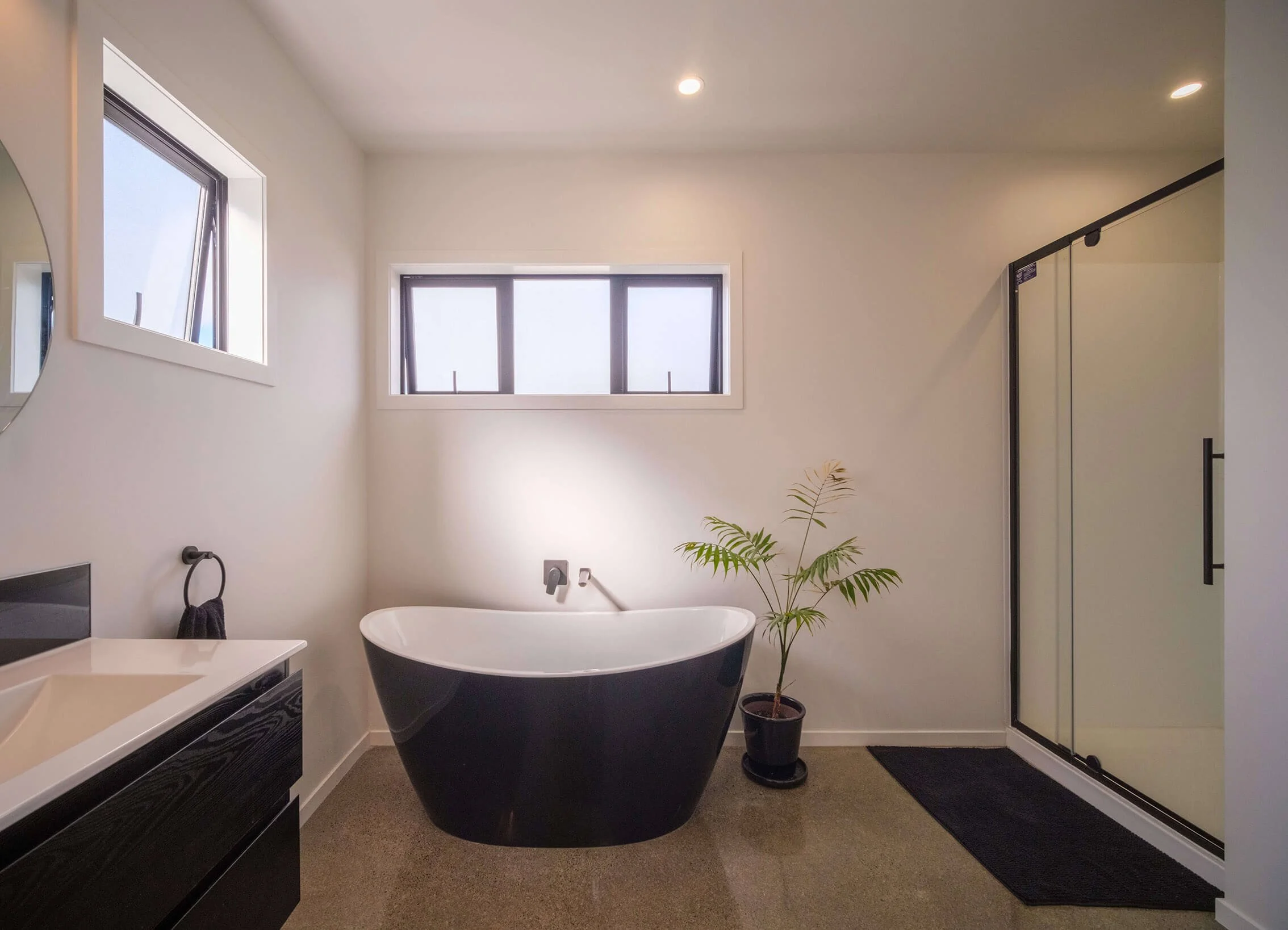 Black bathroom fixtures in a light contemporary design with polished concrete floor