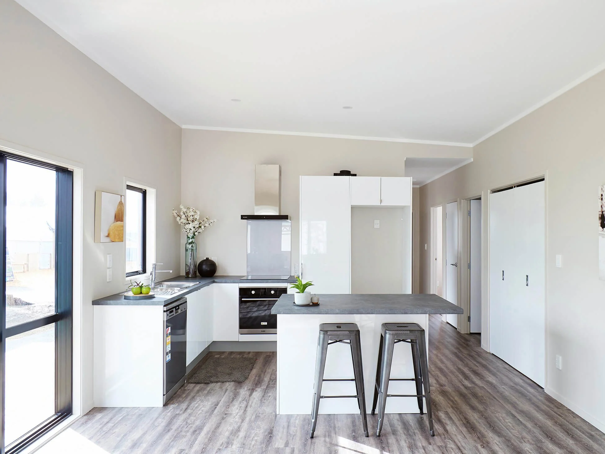 brand new kitchen with island, white cabinetry, grey benchtops and vinyl flooring