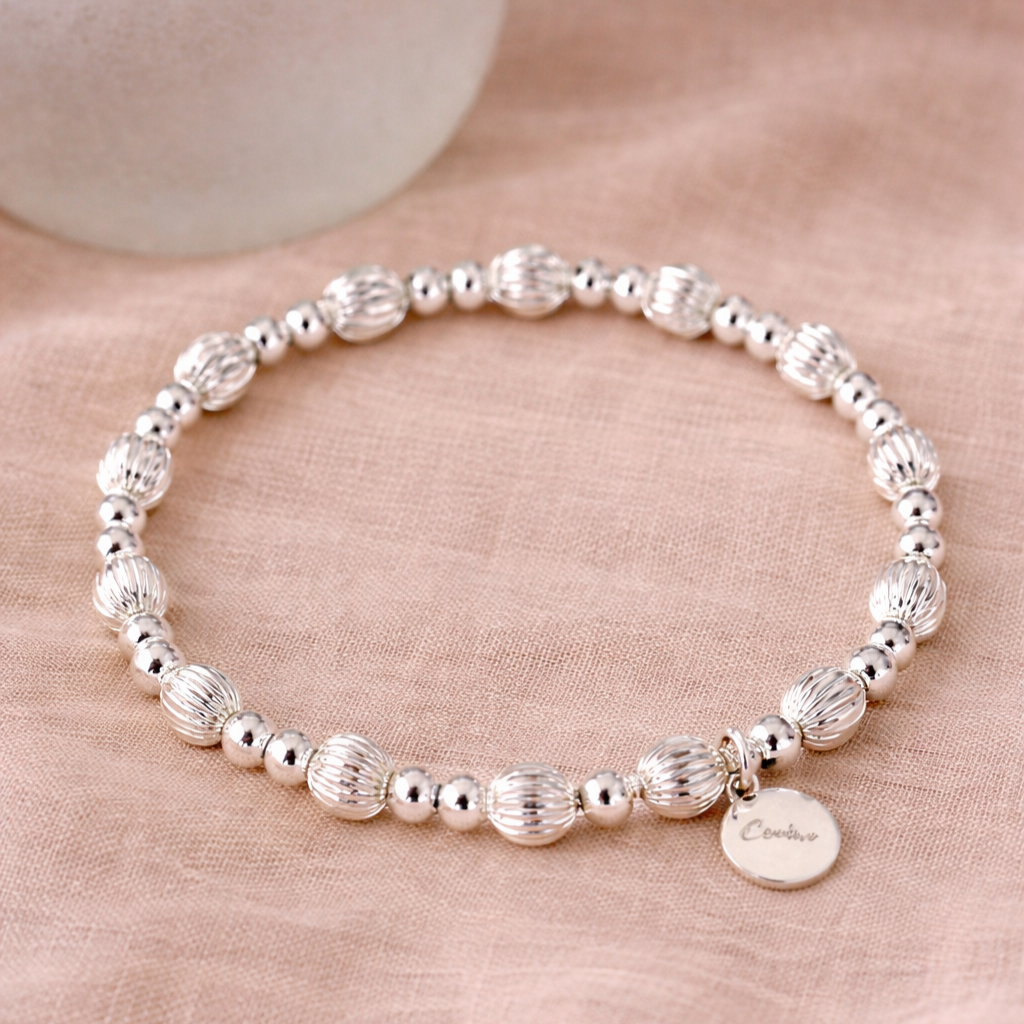 Shiny+silver+bracelet+on+beige+fabric.png