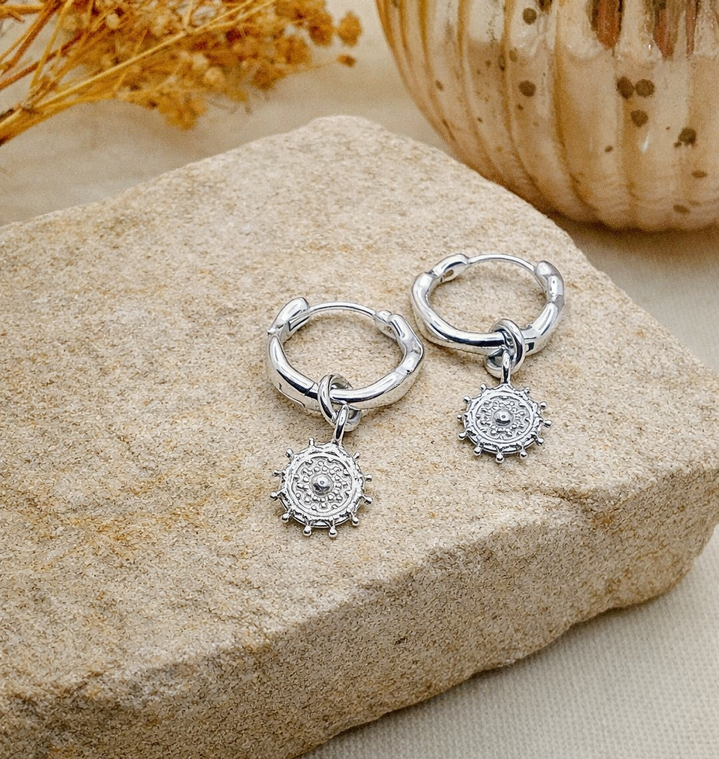 Tribal charm earring on sandstone block.png
