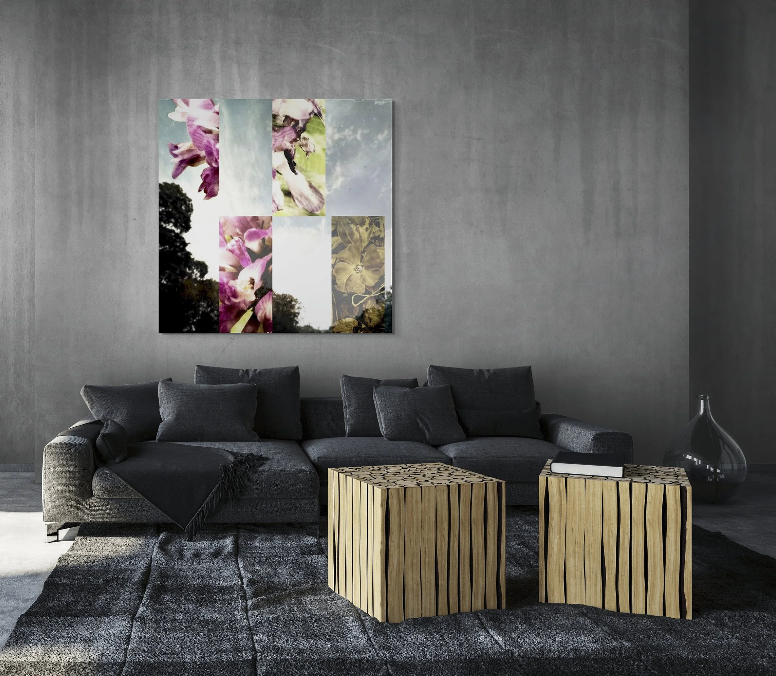 This mock-up shows print of Surreal digital composite, Clover, on gray concrete wall with concrete floor, dark gray couch with black accents and two cubic tables of pale wood and black resin.