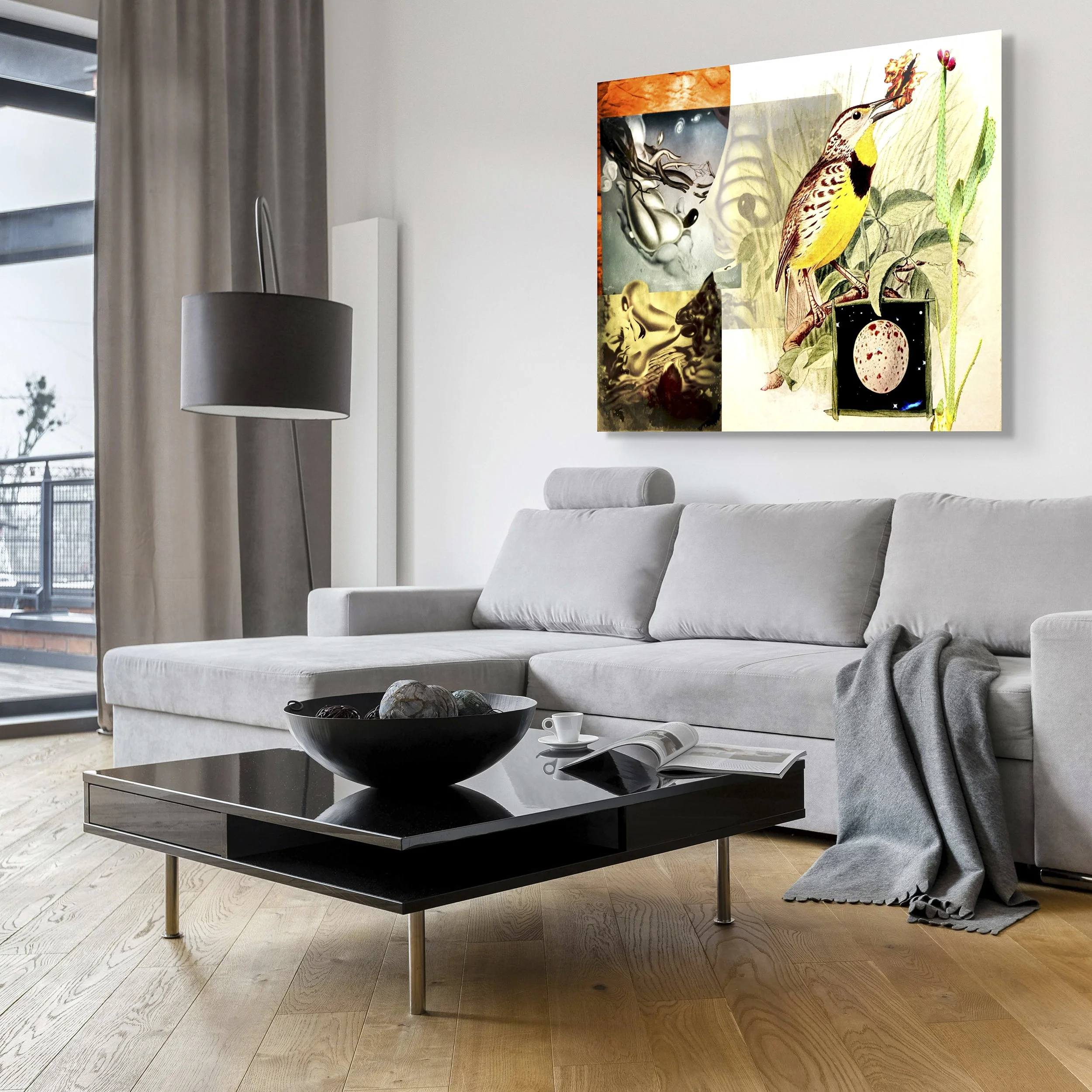 This mock-up shows print of Surrealist digital composite, Orthographic Projection with Bird and Cactus, on gray wall in modern room with window-wall, black and gray furnishings and wooden floor.