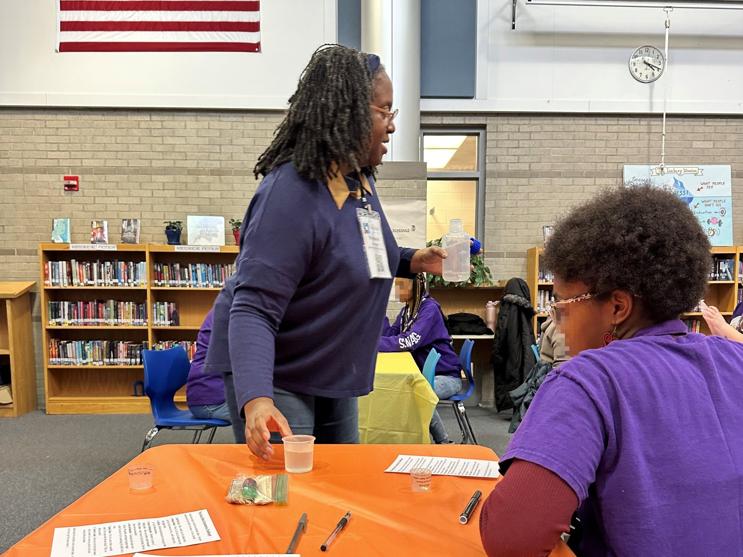 STEM mentor guiding middle school students through a hands-on quality engineering activity at the ECLN SWAG program. This interactive session emphasizes process validation and structured problem-solving in STEM education.