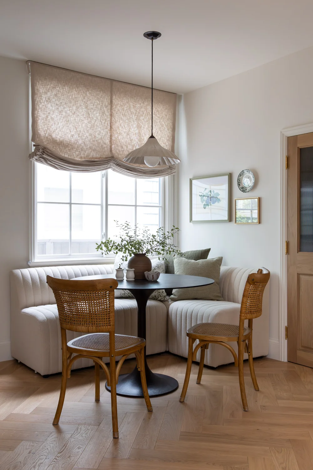 Breakfast nook with a banquette and rattan chairs at the 5th Street home in Manhattan Beach