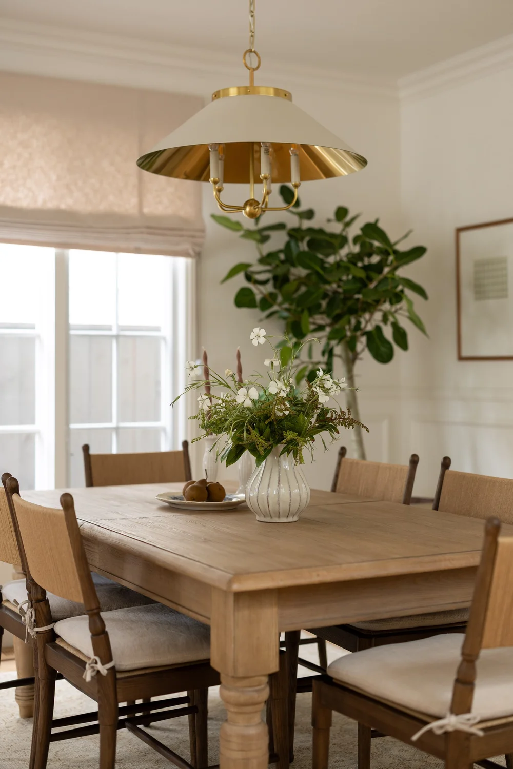 Styled dining table with a brass pendant at the 5th Street home in Manhattan Beach