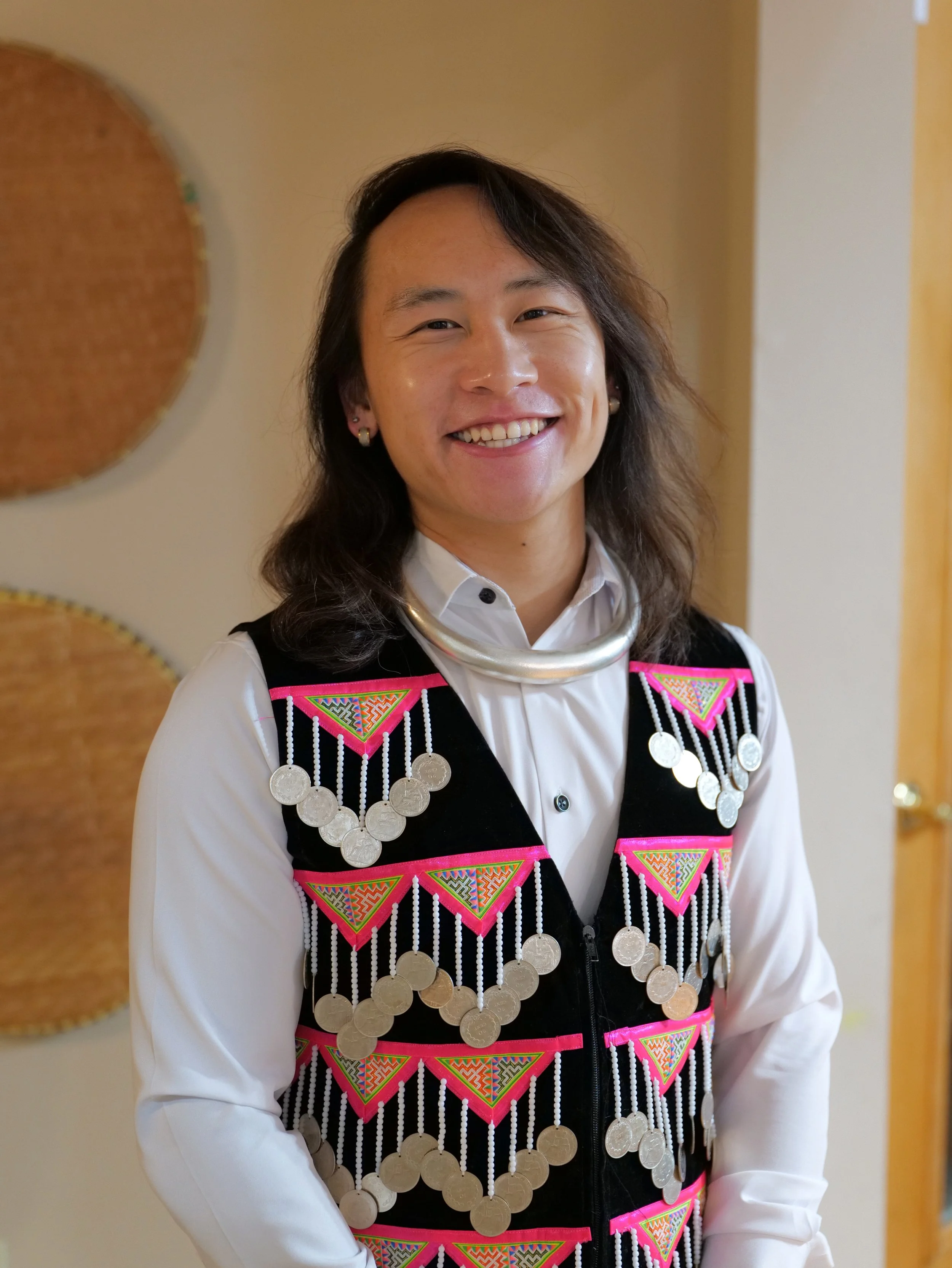 Loshi Vue, Hmong American Registered Dietitian wearing traditional wear as a sign promoting balance with cultural practices and cultural foods.