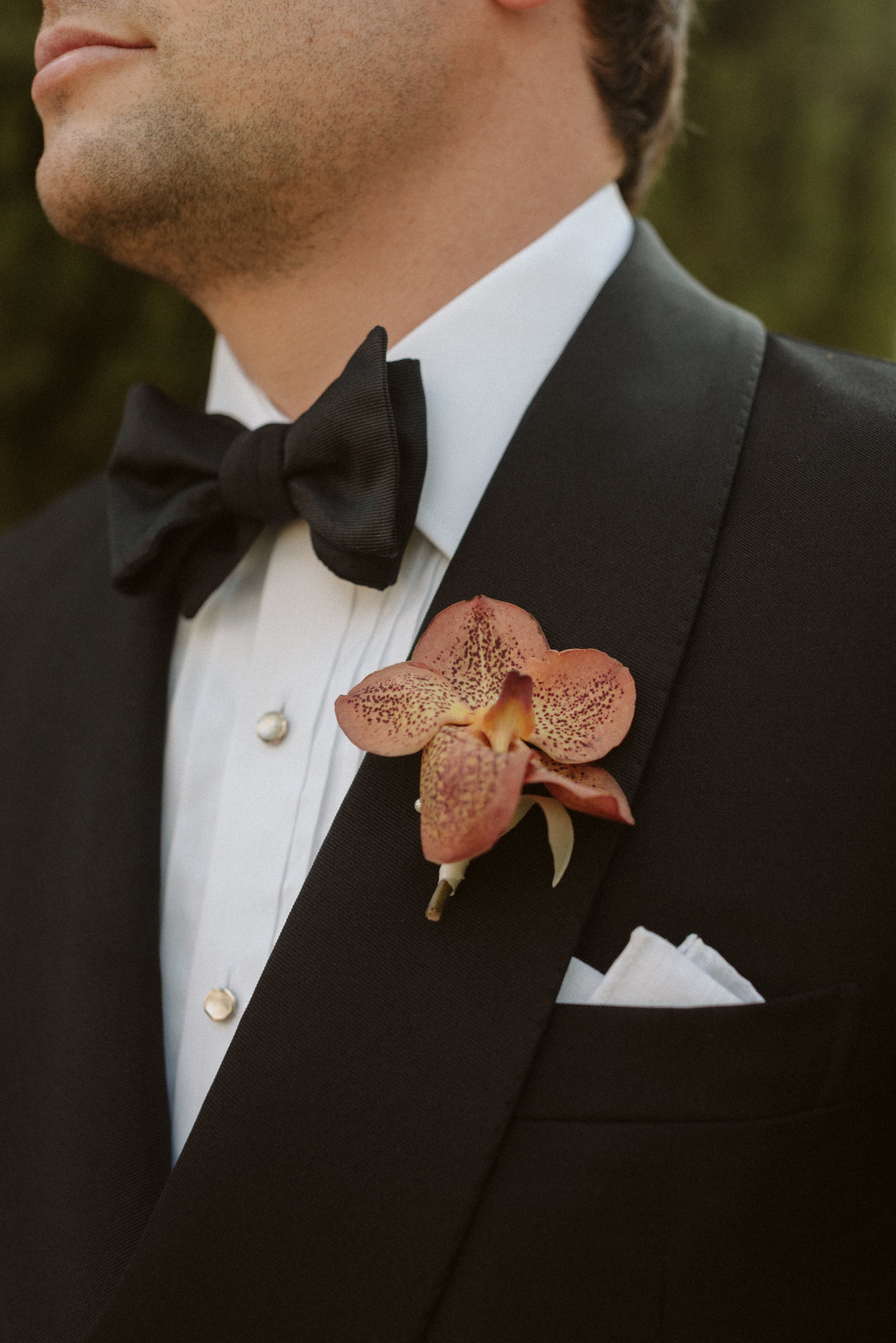  Groom wearing a contemporary buttonhole with orchids for his wedding at the Villa Cetinale in Italy 