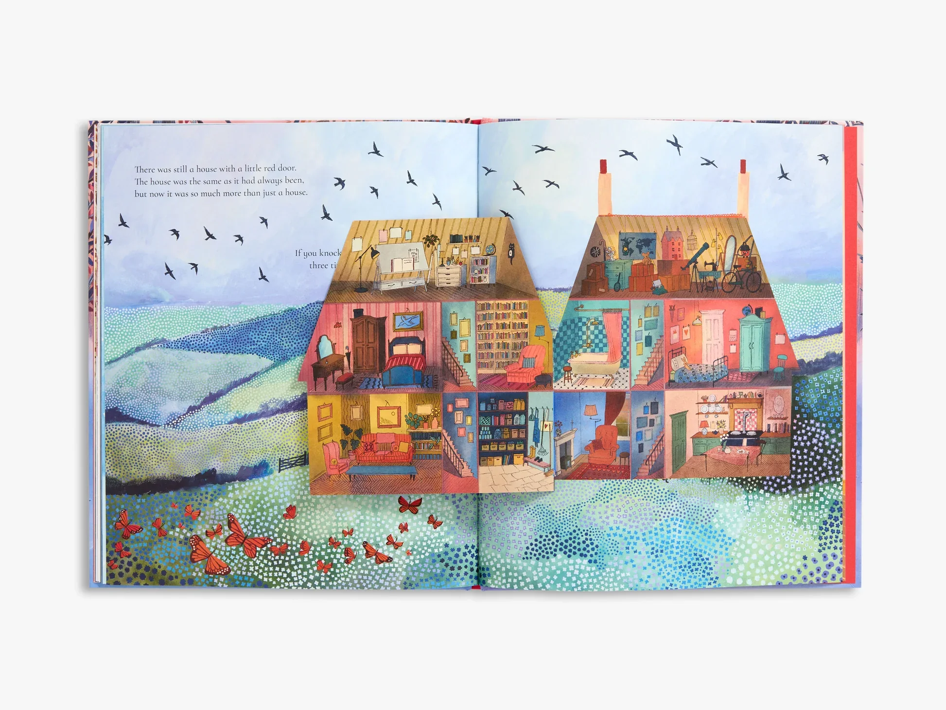 A colorful children's book illustration showing the cross-section of a house with multiple rooms filled with furniture and objects, set against a scenic background of rolling green hills, blue sky, and flying birds.