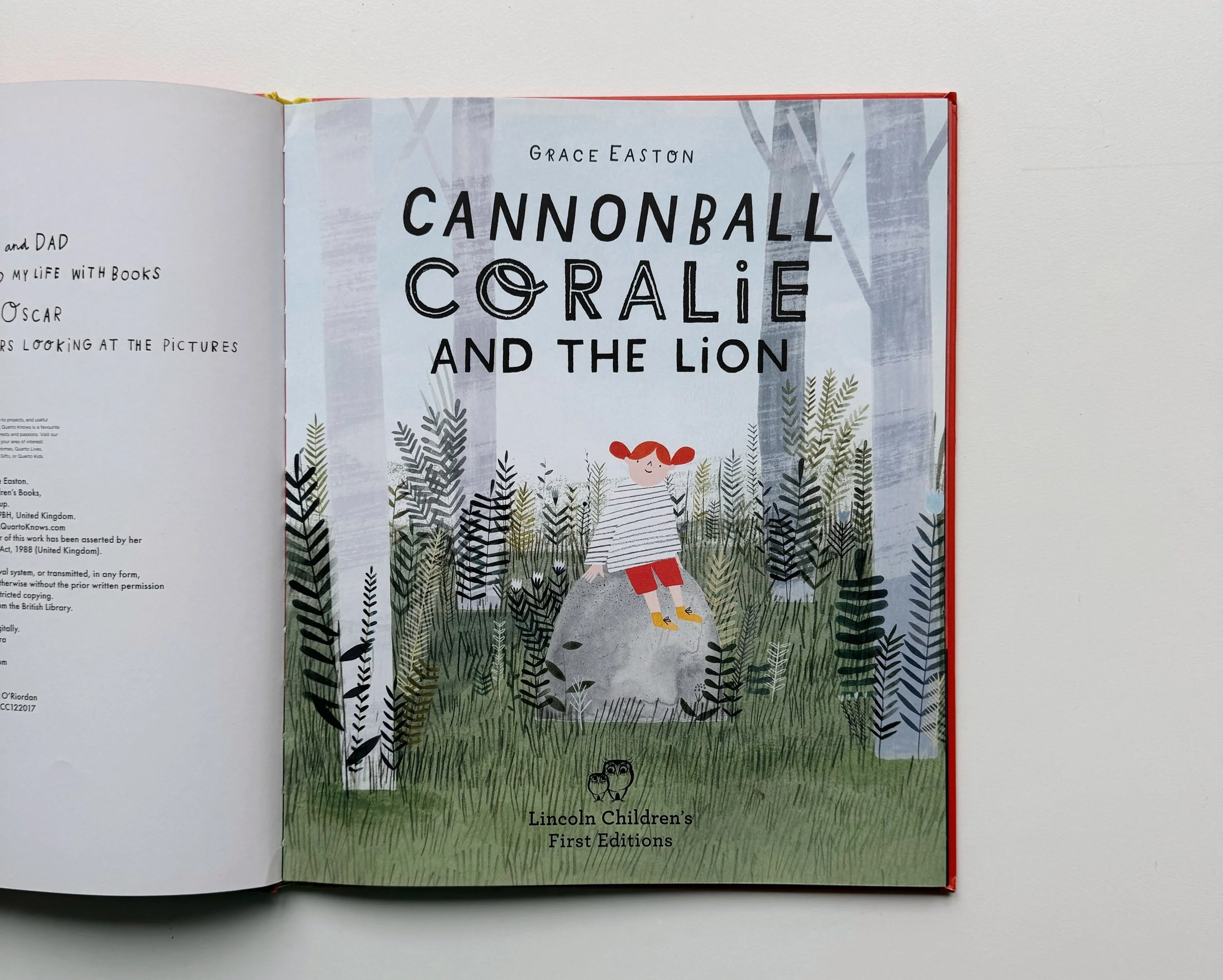 Front cover of a children’s book titled "Cannonball Coralie and The Lion" by Grace Easton, featuring an illustration of a girl with red hair, standing among trees with an owl at her feet, in a forest scene.