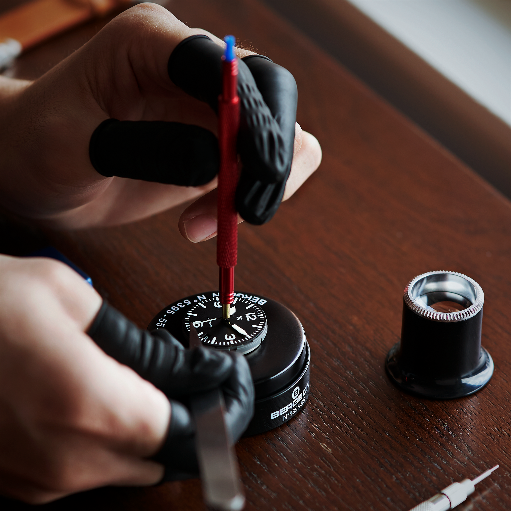 Fitting watch hands to a dial with a red hand-setting tool