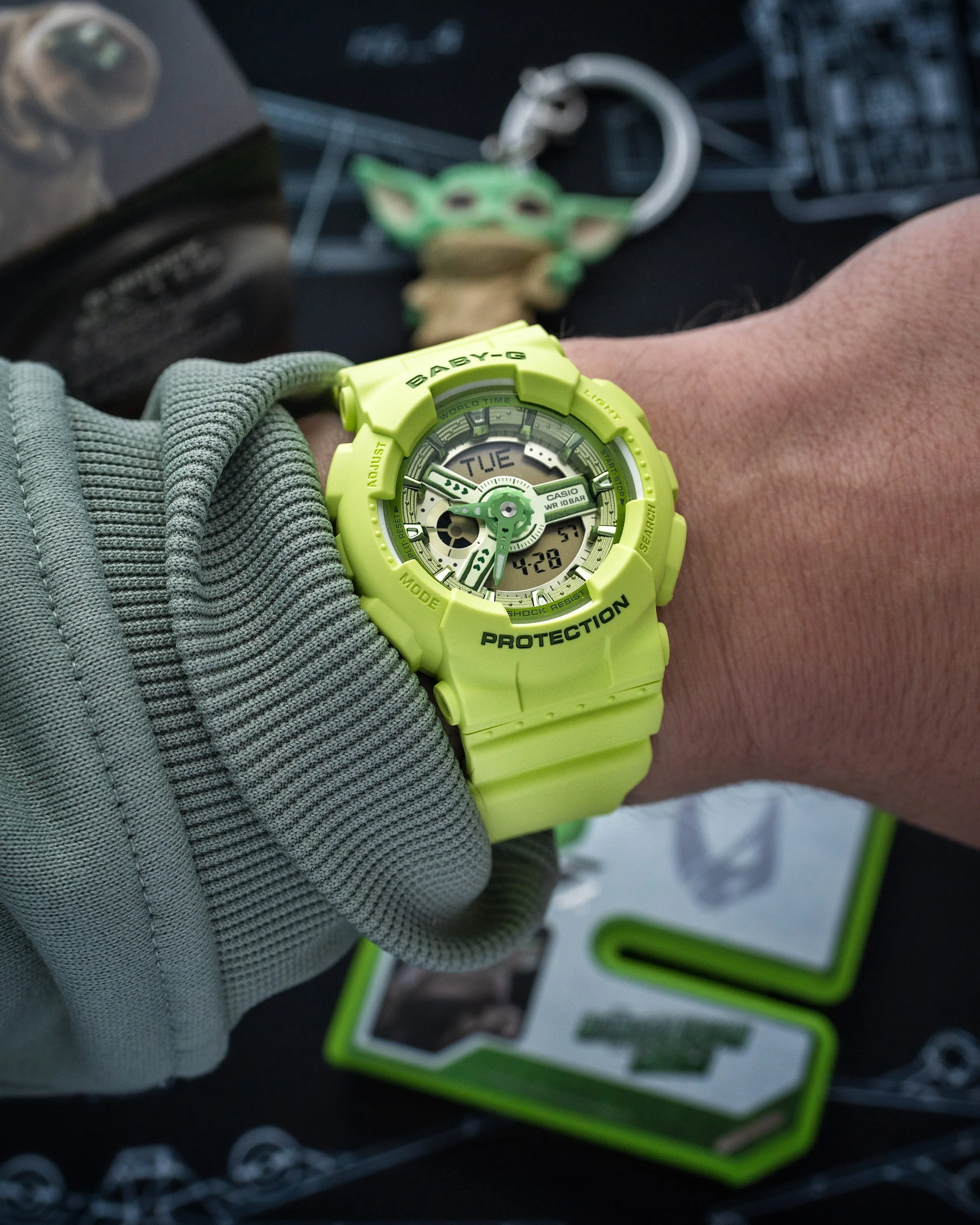 Baby-G BA-110 Grogu watch shown on wrist with vivid green case, layered dial and resin strap