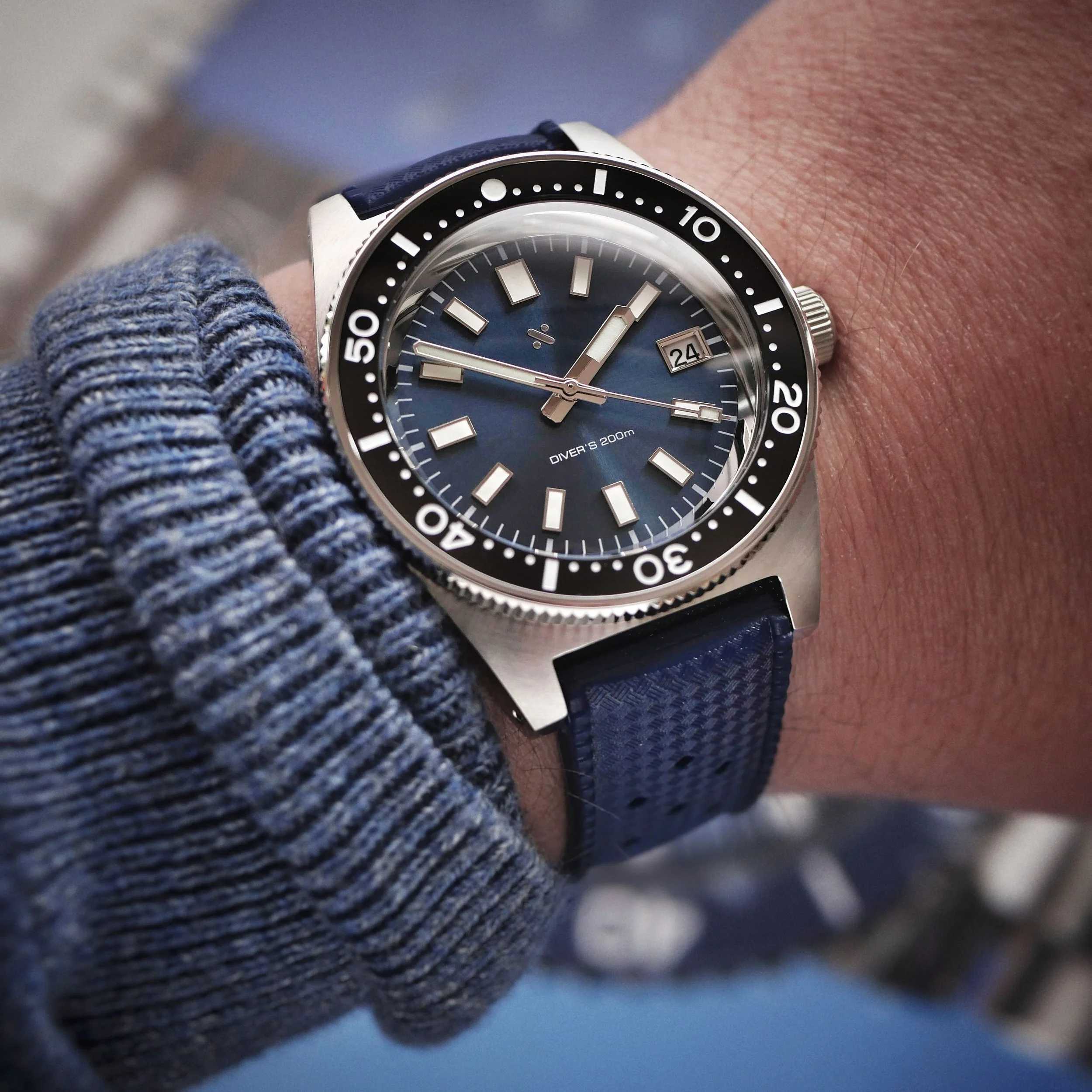 Blue-dial Namoki NMK07 on the wrist with a dark blue tropic-style rubber strap.